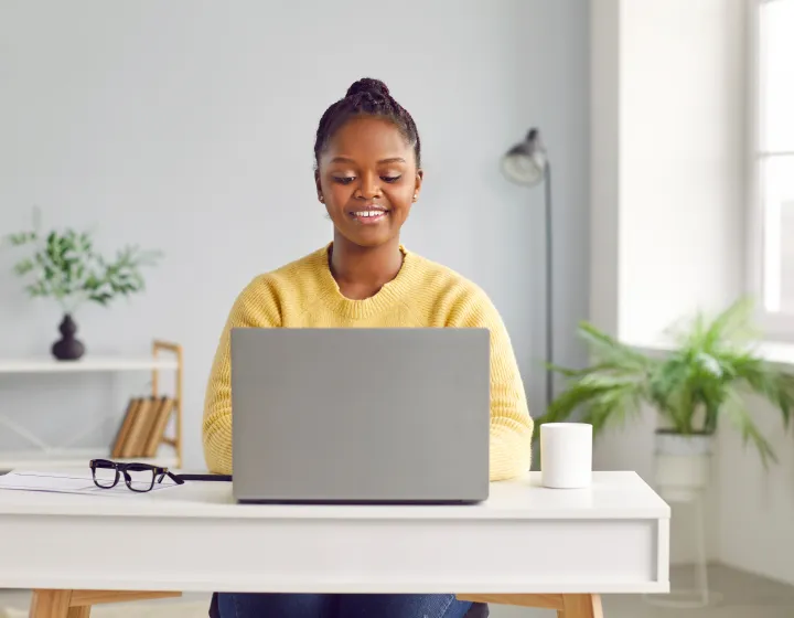 A woman working on her laptop at a desk